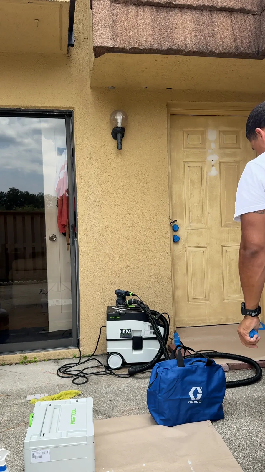 The courtyard covered with a drop cloth and the tools set up before work on the door