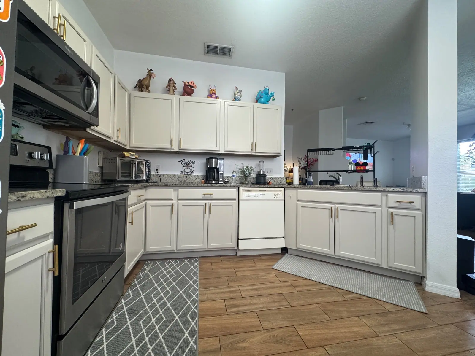The same Winter Garden kitchen with the cabinets painted soft cream and brass pulls