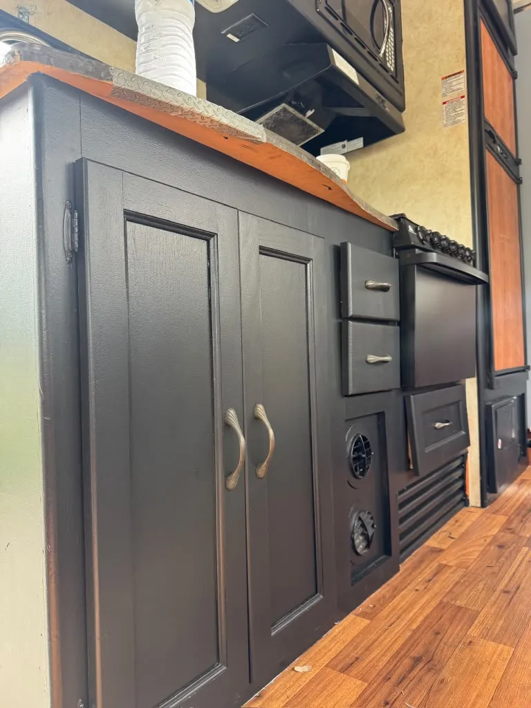 Close-up of cabinet doors and drawers painted smooth satin black with brushed nickel pulls