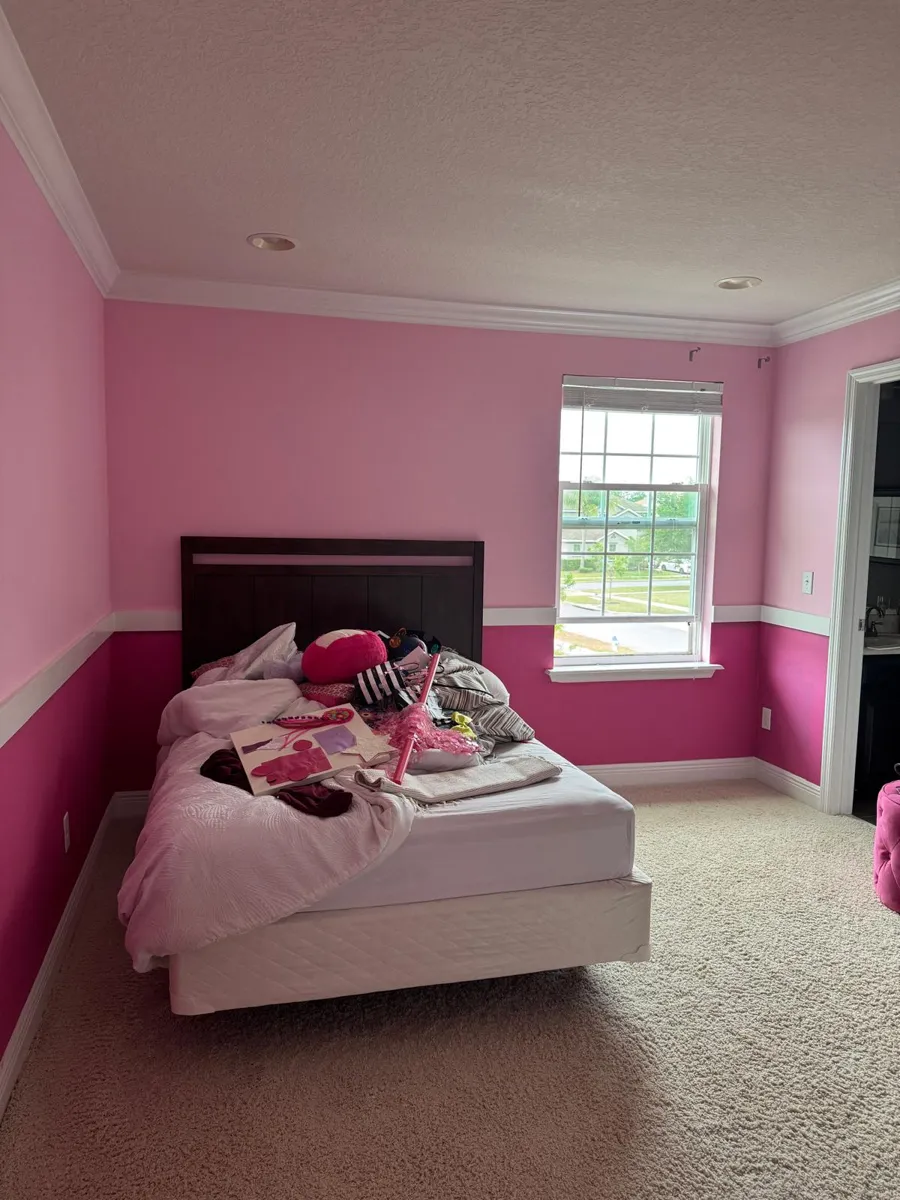 The finished bedroom in soft pink and deep magenta with the bed by the window