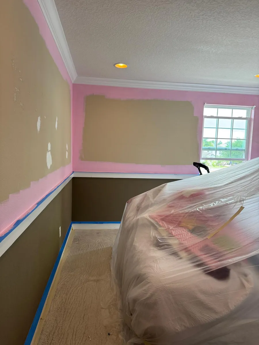 Pink paint going on above the chair rail while the bed stays wrapped